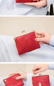 Detail of vintage red wallet showing the golden metal frame clasp and leather texture