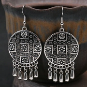 Gros plan de boucles d'oreilles vintage en argent avec gravure florale et gouttes