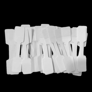 Macro shot of blank white jewelry price tags on a solid black background