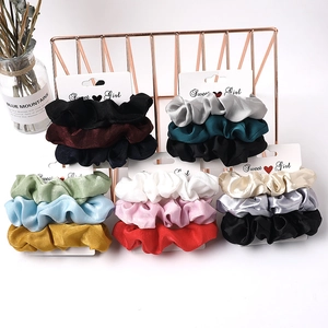 Close-up of premium satin scrunchies set in assorted colors on display cards