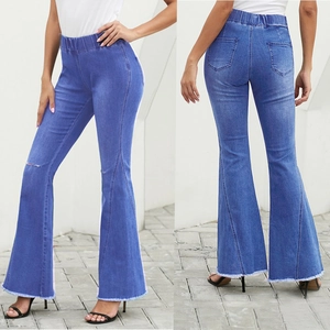 Detail of blue high-waisted distressed flare jeans with ripped knees and raw hems