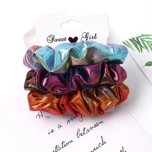 Three metallic fabric scrunchies in blue, purple, and orange on Sweet Girl card