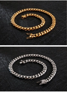 Detail of gold and silver cuban link necklaces with diamond-encrusted buckles on dark surface