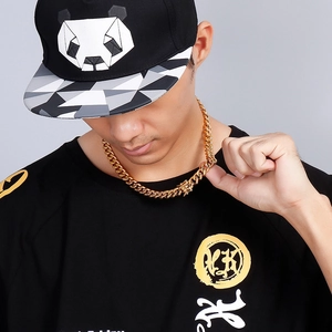 Men's bold golden Cuban link chain necklace shown on a model in a professional studio setting