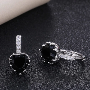 Macro shot of silver heart earrings featuring black zircon stones and micro-pave crystals