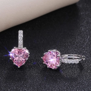 Elegant heart-shaped pink zircon earrings in silver finish on a black textured surface