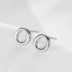 Macro shot of polished silver stainless steel hoop earrings on a clean background