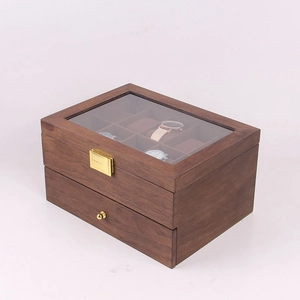 Détail du coffret montre en bois de noyer avec couvercle en verre et serrures dorées