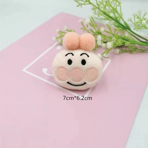 Macro view of a cute pink plush cartoon doll accessory with size dimensions 7cmx6.2cm