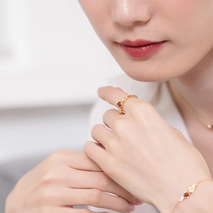 Close-up of 925 sterling silver gold plated ring featuring a red garnet stone on model's hand