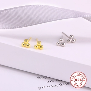 Detailed macro view of S925 sterling silver triple ball cluster earrings in gold and silver