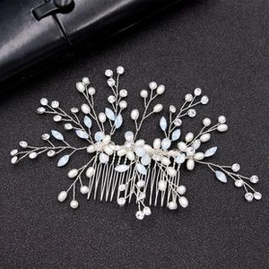 Detailed close-up of bridal hair comb with white pearls and clear crystals on silver wire