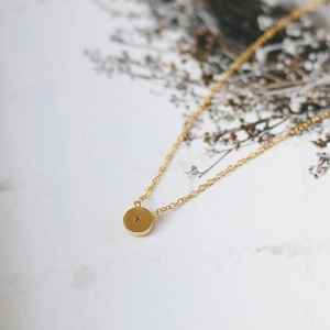 Detailed close-up of zircon pendant on 18K gold plated titanium steel necklace
