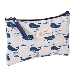 Detail shot of canvas makeup bag with blue whale pattern and durable navy zipper