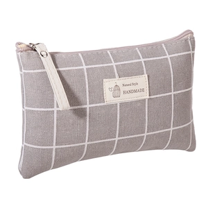 Detail of grey checkered fabric storage bag with beige handle and Natural Style label
