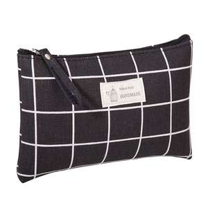 Detail of checkered canvas makeup bag featuring a natural style handmade woven label