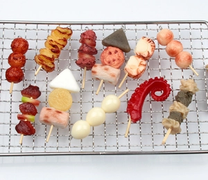 Detailed view of assorted realistic food charms like octopus and meatballs on a metal rack