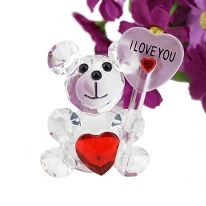 Detail of crystal bear figurine with red heart and I LOVE YOU lollipop on white background