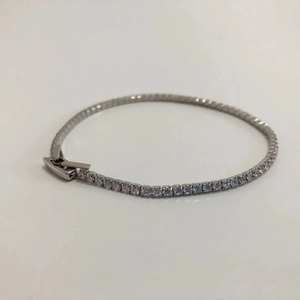 Close-up of classic silver tennis bracelet featuring a row of round-cut sparkling zircons
