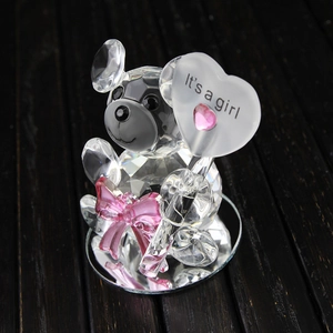 Crystal bear figurine with pink bow and heart sign on a reflective base for baby shower