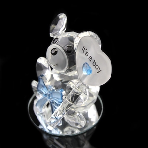 Macro shot of crystal bear holding heart sign with It's a boy text for baby shower gifts