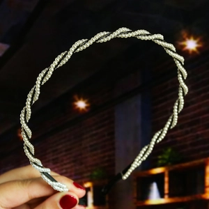 Detail showing hand-woven black and white pearl headband with elegant knotting texture