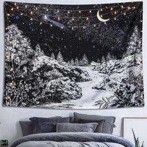 Cozy bedroom wall hanging with a black and white celestial forest tapestry and warm string lights