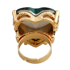 Macro shot of gold adjustable ring base and green stone inlay from a top-down view