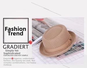 Detail of breathable woven fedora with mesh texture, ribbon band and metal V logo