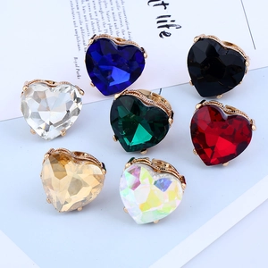Detailed close-up of heart-shaped gemstone rings in various colors with golden bands