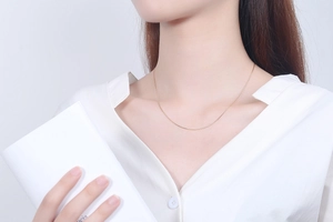 Close-up of minimalist gold 925 sterling silver snake chain worn by a female model