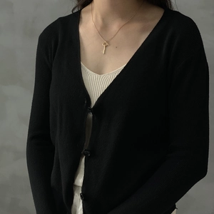 Close-up of a vintage 925 silver key pendant necklace in gold finish worn by a model