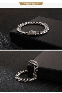 Detailed macro of silver Cuban link bracelet with diamond-encrusted clasp on black background