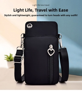 Détail du petit sac bandoulière noir avec fermeture cœur et trou pour écouteurs