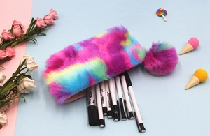 Vista dettagliata dell'astuccio in peluche arcobaleno con morbida decorazione pompon
