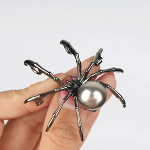 Close-up of spider brooch with gunmetal finish, grey pearl abdomen and rhinestone legs