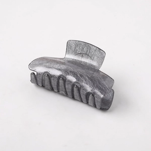 Macro shot of silver-gray shark hair clip with brushed metal texture and sturdy teeth