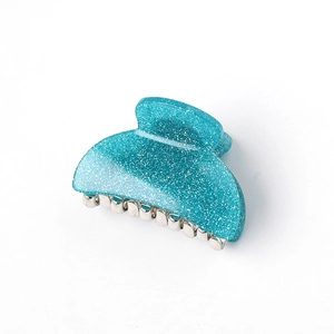 Close-up of sky blue acrylic hair claw clip with shimmering glitter and metal spring