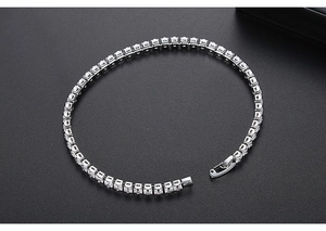 Macro shot of a silver square-cut zircon tennis bracelet with a secure clasp on black background