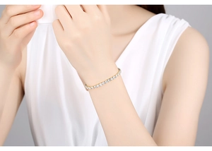 Close-up of gold tennis bracelet with round clear cubic zirconia on a female wrist