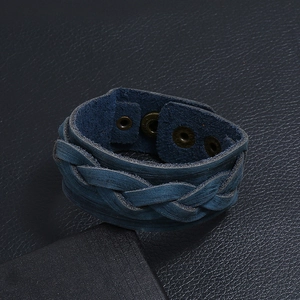 Close-up of wide braided blue leather bracelet with metallic snap button fasteners