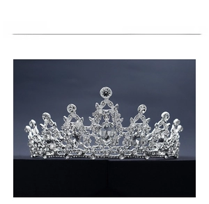 Close-up of silver baroque crown featuring intricate scrollwork and water-drop crystals