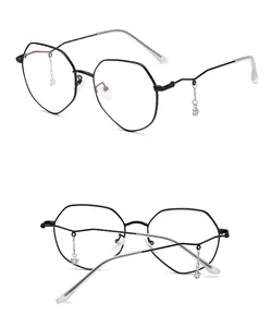 Detail of black polygonal metal glasses frame featuring star and crystal pendant chains