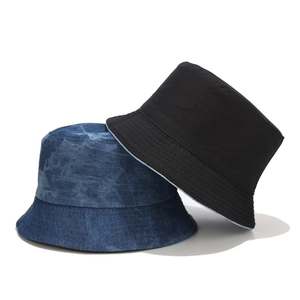 Dettaglio del cappello alla pescatora in denim tie-dye vintage e cappello da sole nero