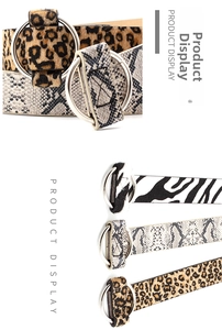 Detailed view of silver double ring buckle on leopard and snake print leather belts