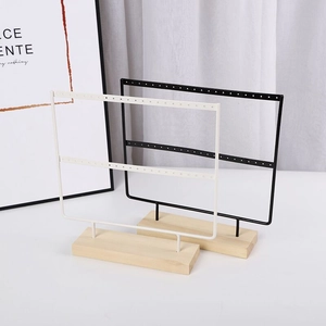 Detail of iron earring stand with pine base showing double-layer holes for jewelry storage