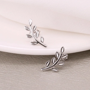 Macro detail of leaf-shaped S925 sterling silver studs with authentic S925 hallmark