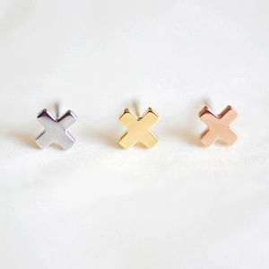 Detailed view of cross-shaped stud earrings in silver, gold, and rose gold finishes