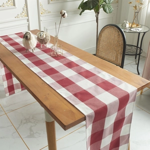 Noorse rood-witte geblokte kersttafelloper op een houten eettafel in huiselijke sfeer