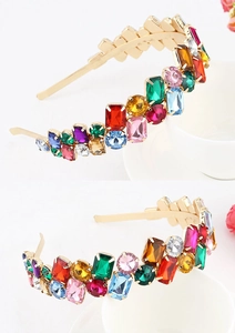 Detailed close-up of baroque style headband with multi-colored rhinestones on gold base